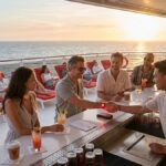 A vibrant cocktail menu at a Virgin Voyages bar showing typical drink costs and the essential free beverage inclusions