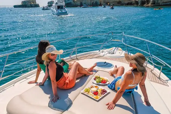 Three women relaxing on a yacht deck while cruising through turquoise tropical waters in Thailand.