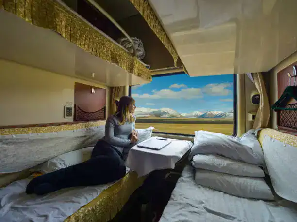 Woman enjoying a scenic mountain view from a train window