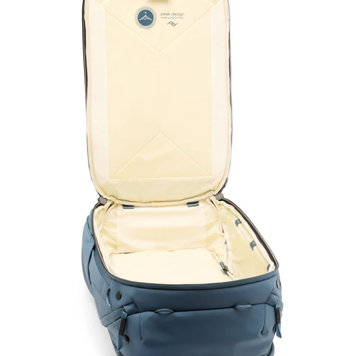 A minimalist blue travel backpack with black base detailing, designed for organization and outdoor adventure, shown against a white background.
