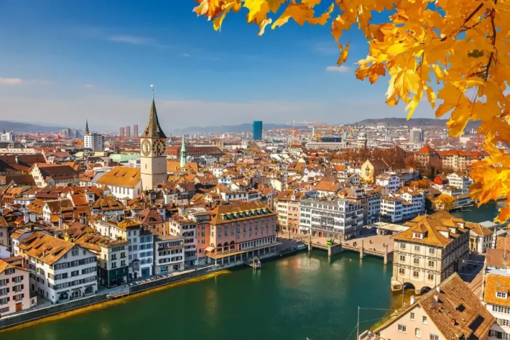 A view of Bern's historic Old Town featuring classic medieval architecture, cobblestone streets, and the iconic clock tower under a clear blue sky.