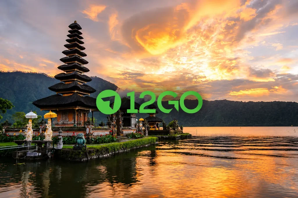 A beautiful sunset view of the iconic Pura Ulun Danu Bratan temple on the water in Bali, featuring the 12GO logo centered against a dramatic golden sky.