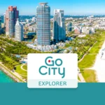 Aerial view of coastal skyscrapers and a sandy beach featuring the Go City Explorer logo in the foreground.