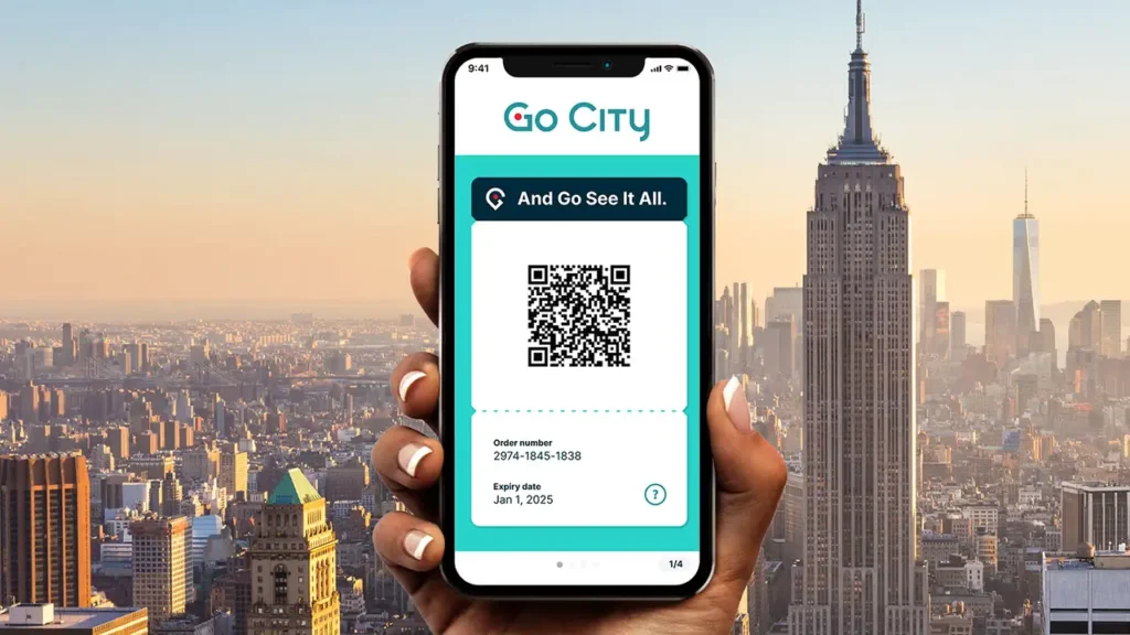 A hand holding a smartphone displaying a Go City digital pass featuring a QR code, order number, and expiry date against a New York City skyline.