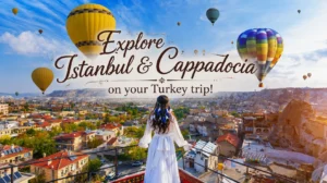 A woman in a white dress on a rooftop overlooking Cappadocia with colorful hot air balloons floating in the sky above