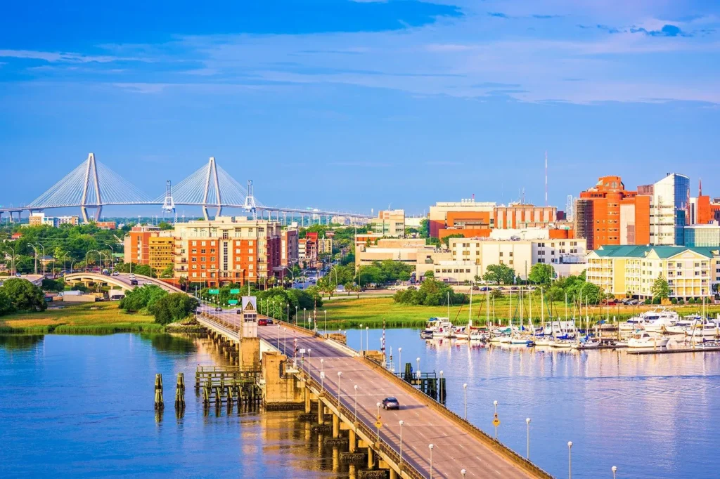 Panoramic view of Charleston, South Carolina, featuring the city skyline, marina, and bridges crossing the water.