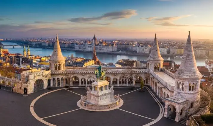Panoramic view of the iconic Fisherman's Bastion, statue, and the Danube River with the Parliament building in Budapest, Hungary.
