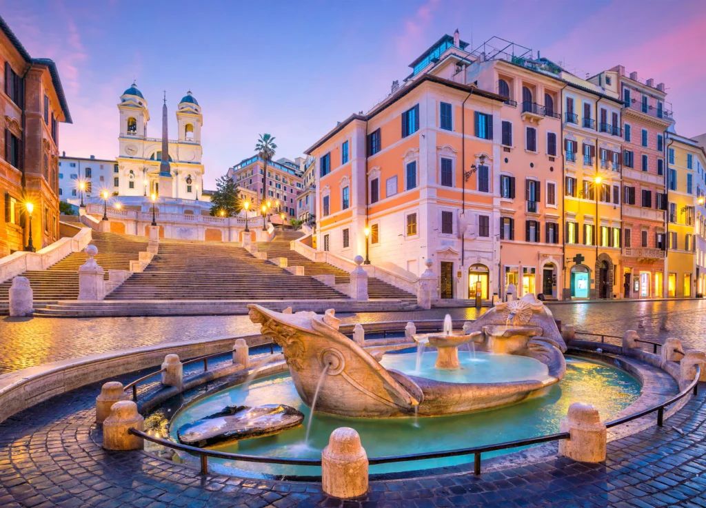 Scenic view of the famous Spanish Steps and the Barcaccia fountain in Rome, Italy, lit up at dusk